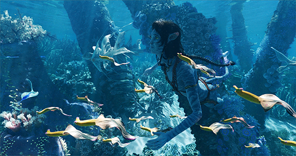 A blue-skinned humanoid swims among colorful coral and glowing sea creatures in a deep blue ocean.