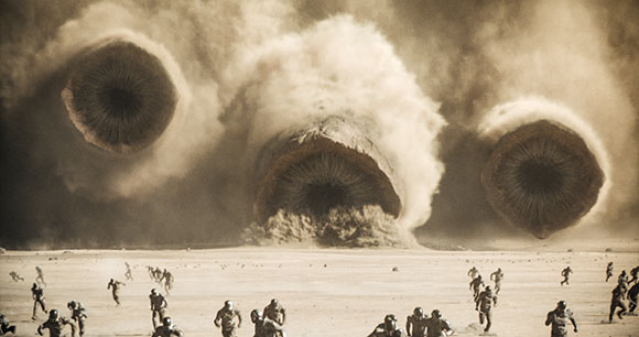 Three giant, circular, textured shapes emerge from massive dust clouds over people running in a desert.