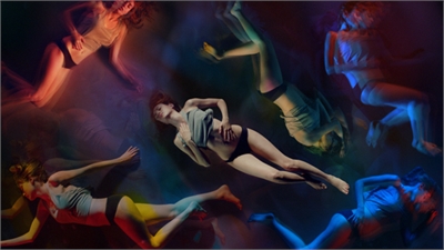 Several figures in swimwear floating in a dark void illuminated by colorful, ethereal light.