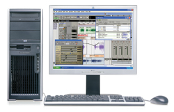 A silver computer tower next to a monitor displaying a digital audio workstation, a keyboard, and a mouse.