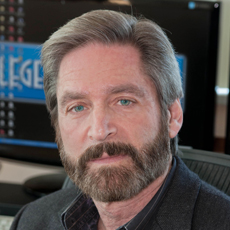 A man with graying hair and a full beard looking toward the camera.