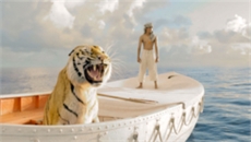 A tiger roars in a small white boat next to a man standing on the ocean.
