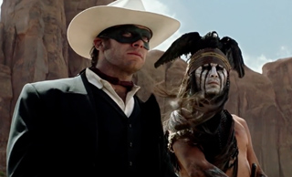 A man in a white cowboy hat and black mask stands beside a person with face paint and a feathered headdress.