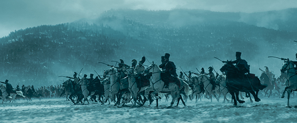A large group of cavalry soldiers riding horses across a vast, snowy field toward a misty mountain.