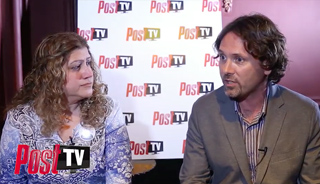A woman with curly hair and a man in a blazer sit in front of a white backdrop with Post TV logos.