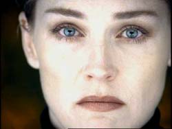 Close-up portrait of a person with light skin and striking blue eyes looking directly forward.
