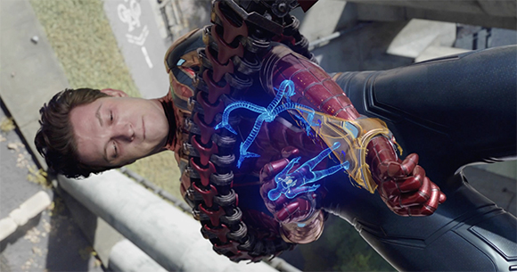 A man in red and gold armor holds a glowing blue holographic figure in his hand.