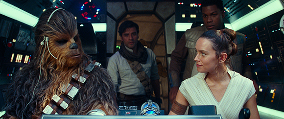 A Wookiee, Rey, Finn, and Poe Dameron inside a spaceship cockpit.