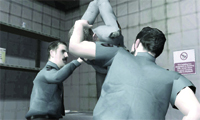 Two men in grey shirts stand in a room with grey tiled walls.
